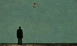 a man staring at a flying dollar bill