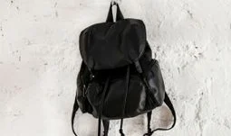 a black rucksack on a white wall 