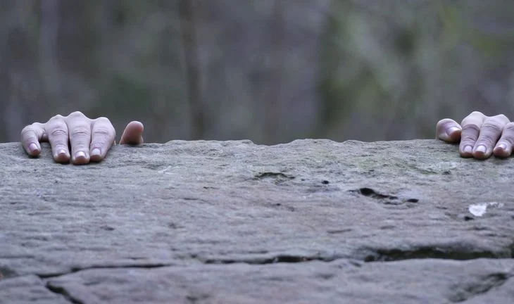 fingers holding onto a rock