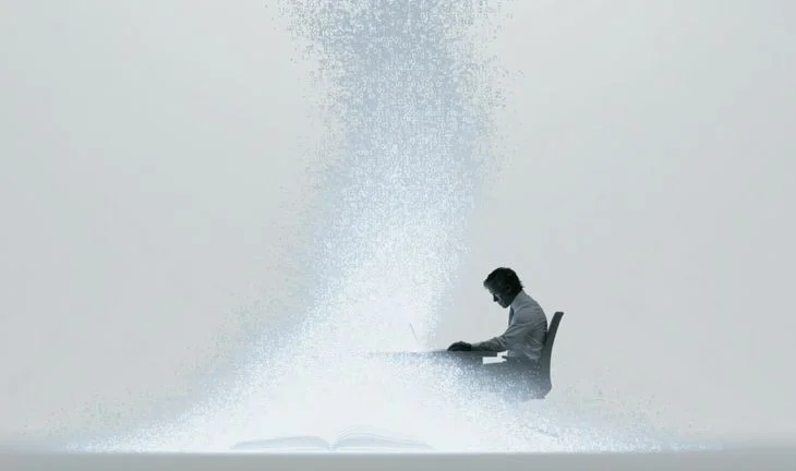 A man sitting at a desk with code rising up
